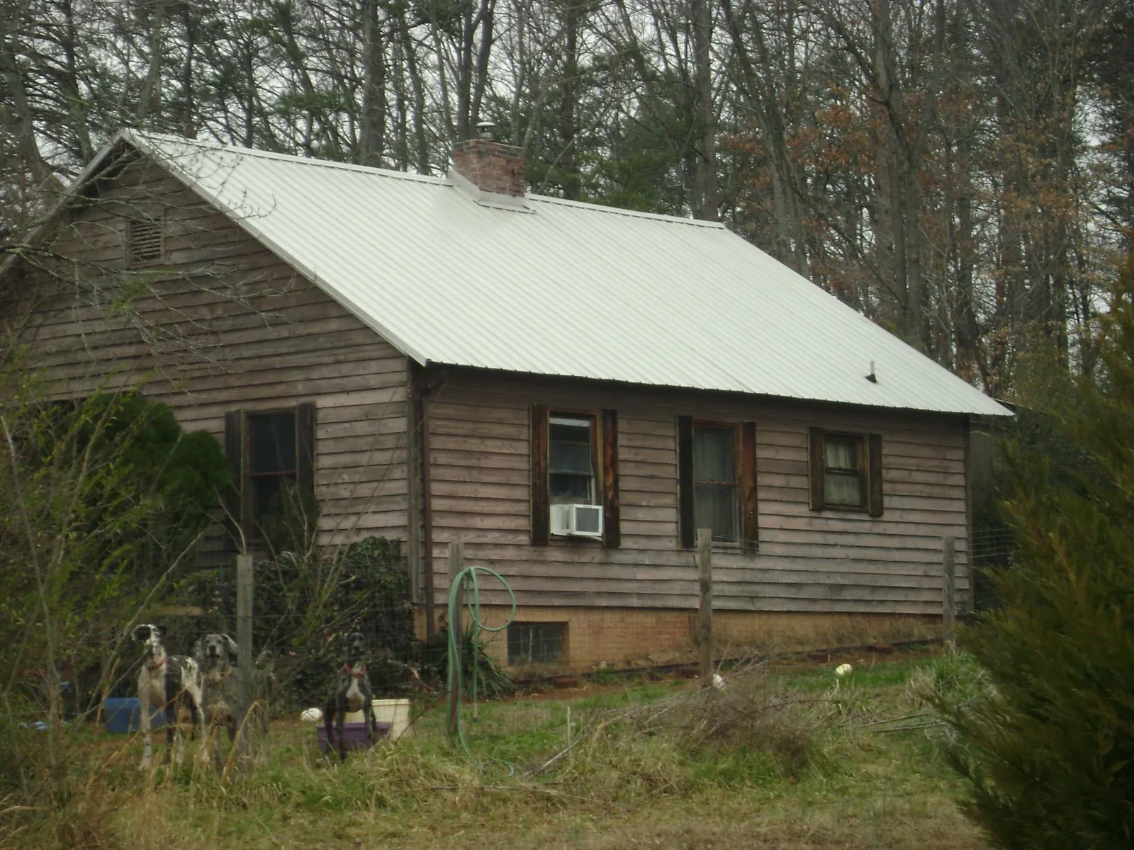White metal roof on an old wood sided farmhouse, from a Metal Roof Installation job in Sardis